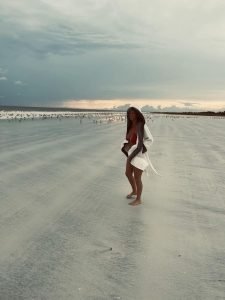 Woman on the beach, by the ocean laughing