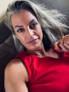 Mandy Katherine Perry sitting in her sofa wearing a red shirt